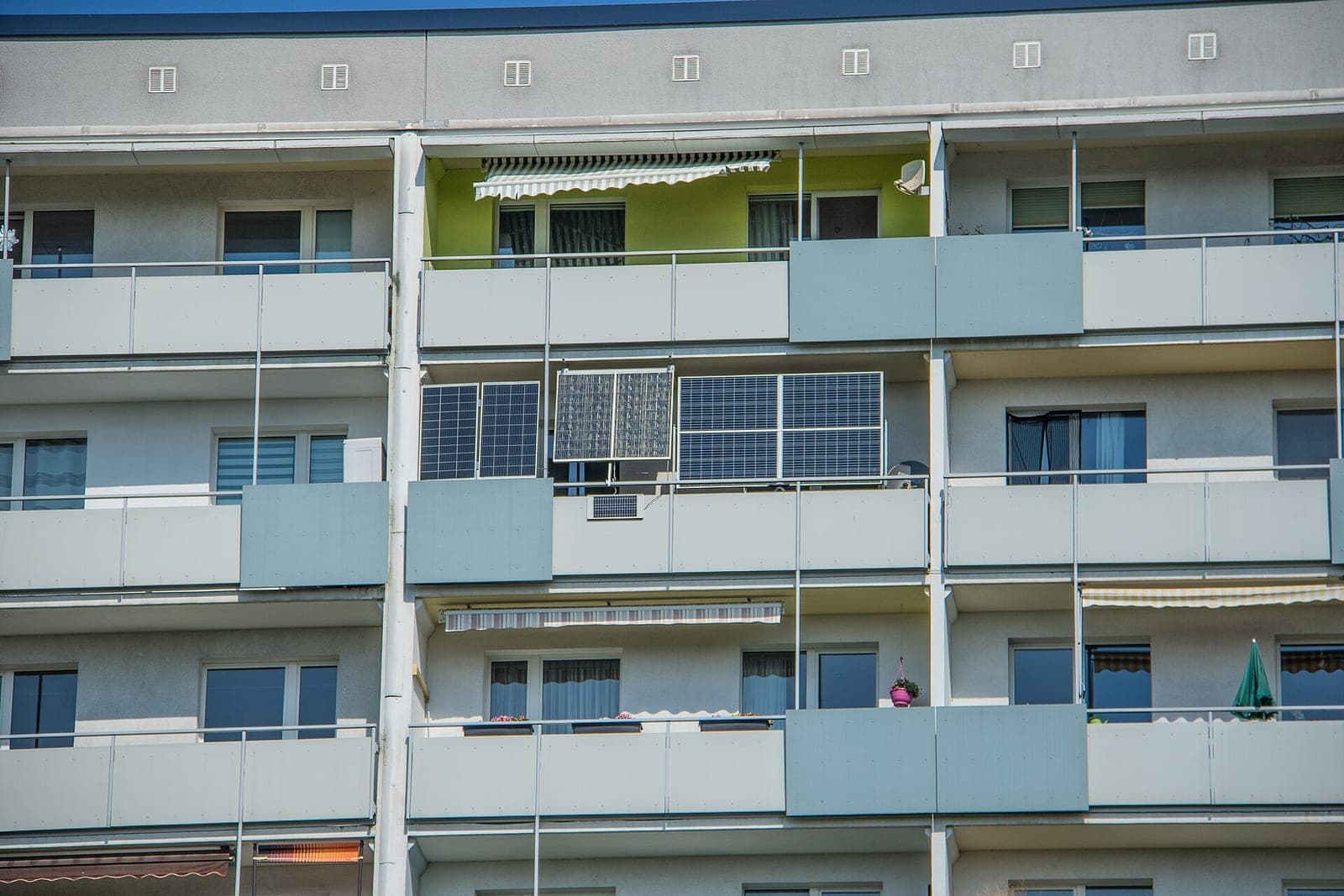 Plug-in solar panels mounted on the balcony railings of an apartment block in Leipzig, Germany, where balcony solar is common