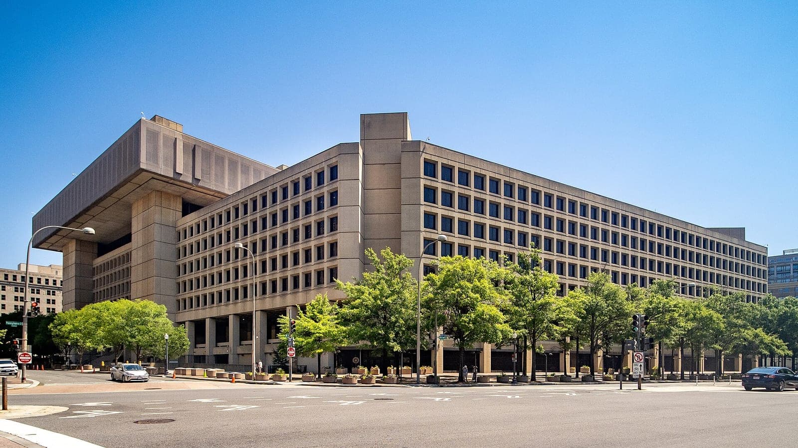 The J. Edgar Hoover Building, the FBI's headquarters in Washington, DC, seen from a street corner on a sunny day