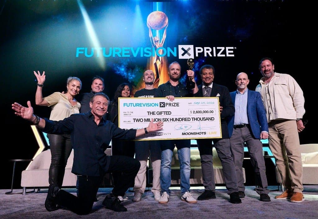 Filmmaker Jeff Synthesized and Future Vision XPRIZE organizers, including Neil deGrasse Tyson, holding an oversized $2.6 million check for 'The Gifted' on stage at Moonshots LIVE.
