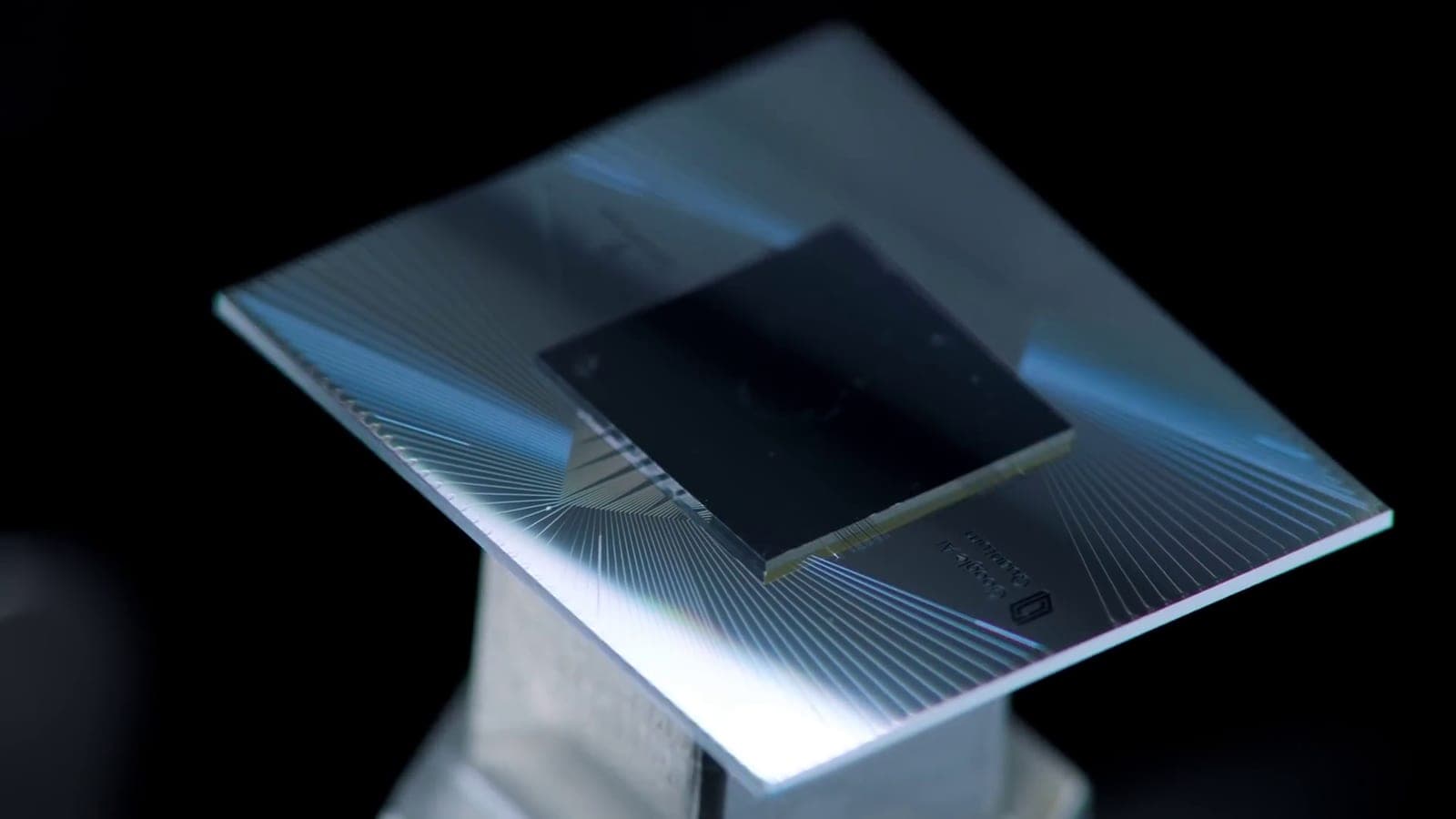 Close-up of Google's earlier Sycamore quantum processor chip on a metal mount against a dark background
