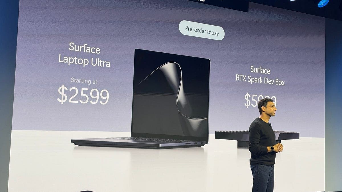 A Microsoft presenter on stage beside a slide showing the Surface Laptop Ultra at $2,599 and the Surface RTX Spark Dev Box at $5,999 with a Pre-order today label