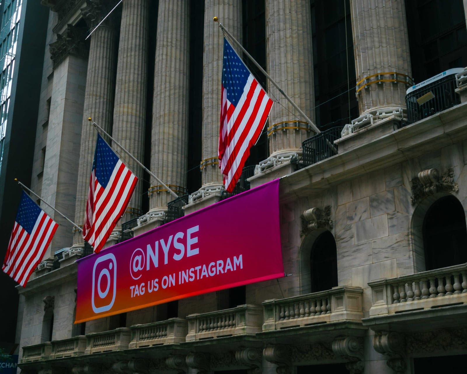 The facade of the New York Stock Exchange building with American flags