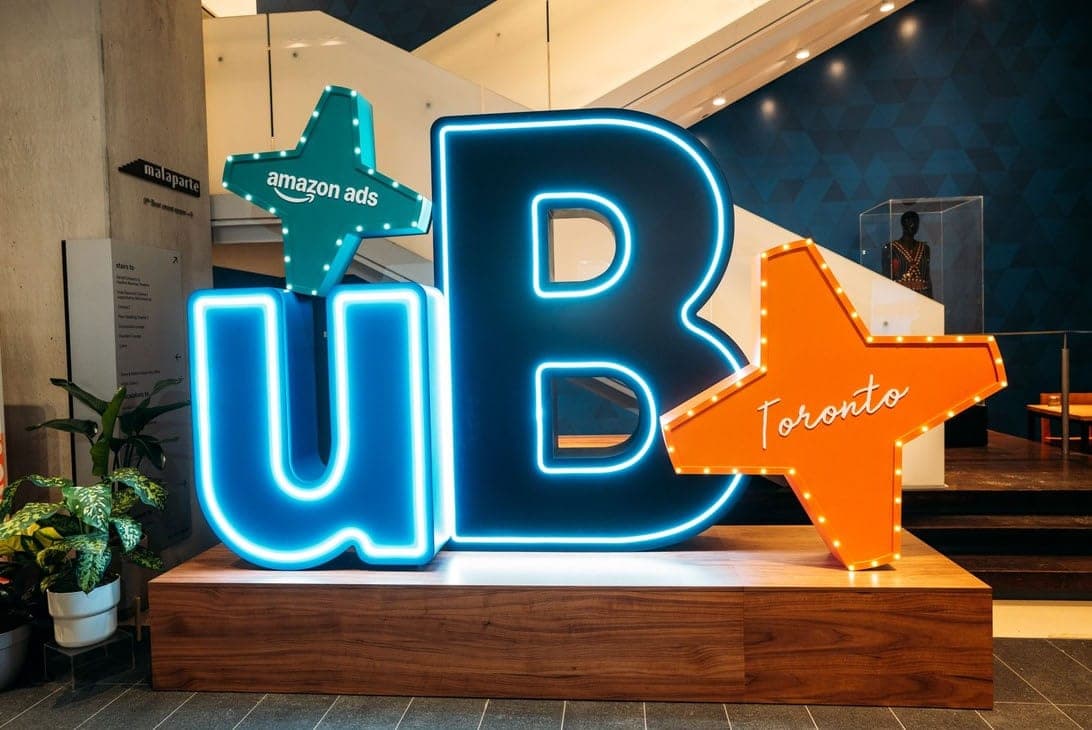 A large illuminated sign reading 'UB' with 'Amazon Ads' and 'Toronto' stars, at the unBoxed 2026 conference venue