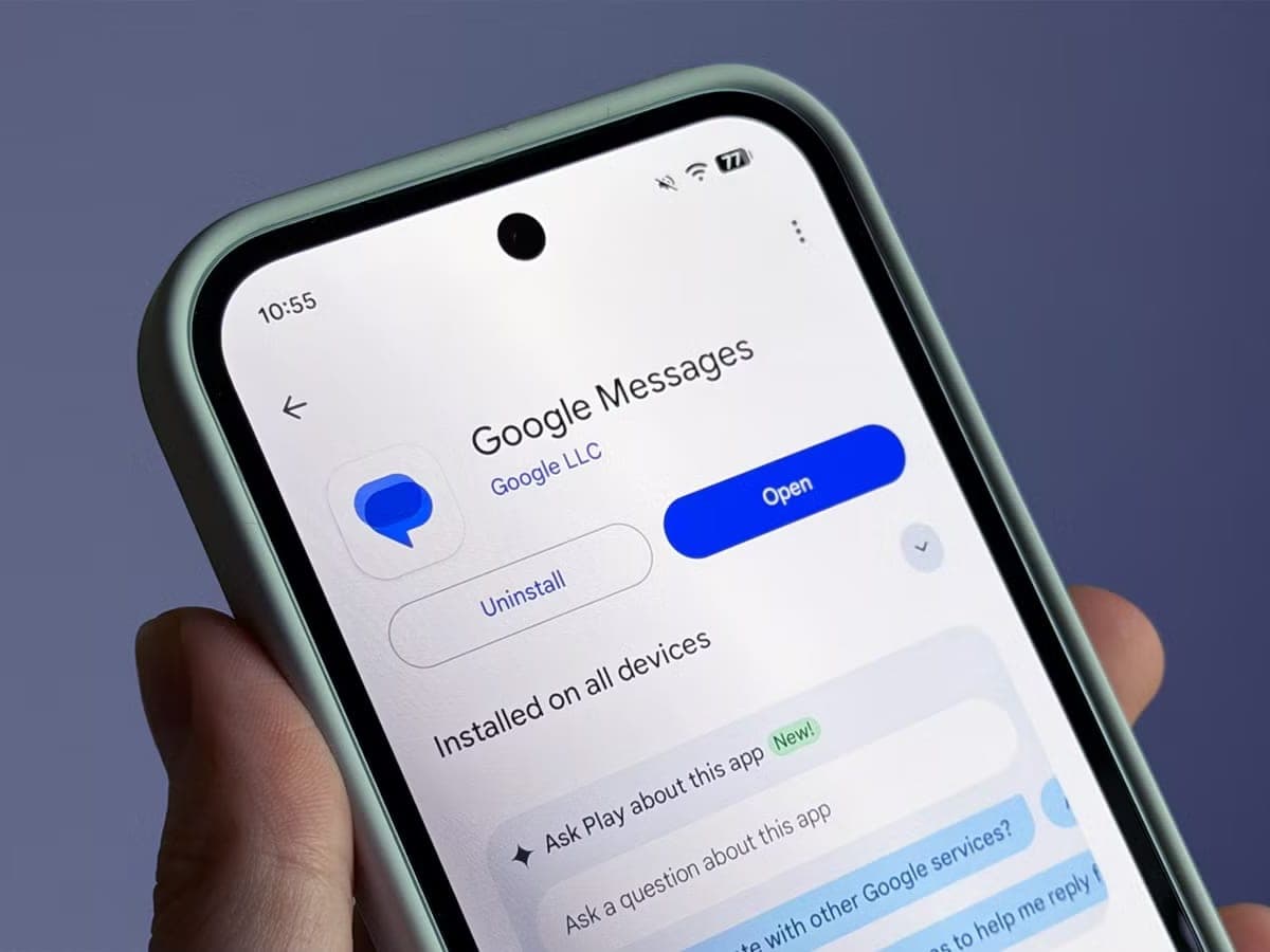 A hand holds an Android phone showing the Google Messages page in the Play Store with an Open button.