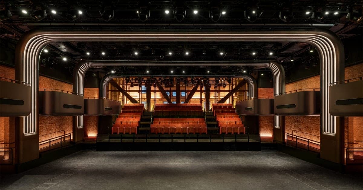 Interior of Apple Music Hall showing tiered red seating facing an empty stage with arched lighting