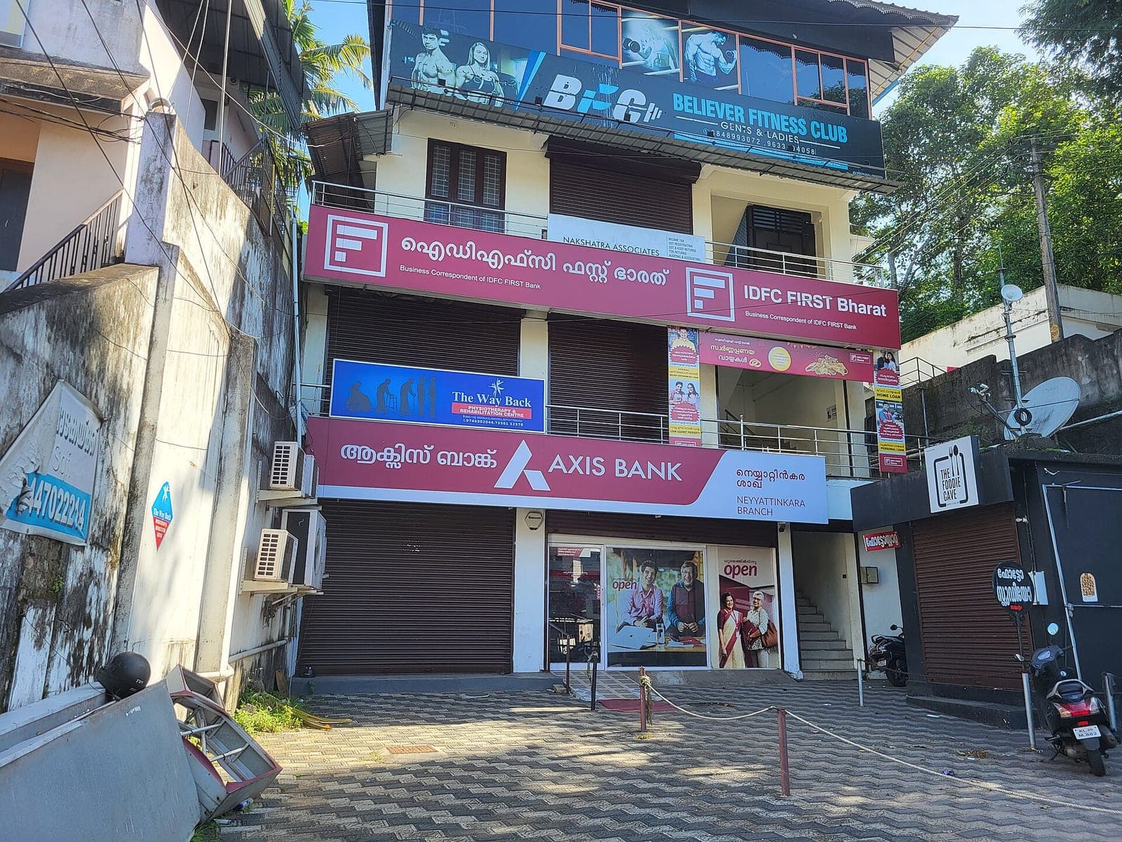 The storefront of an Axis Bank branch in India, with signage in English and Malayalam