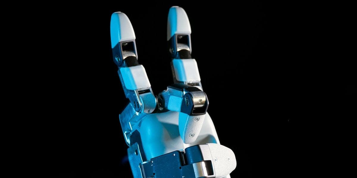 A close-up of a white and blue robotic hand with three fingers and a thumb, making a gesture with two fingers raised