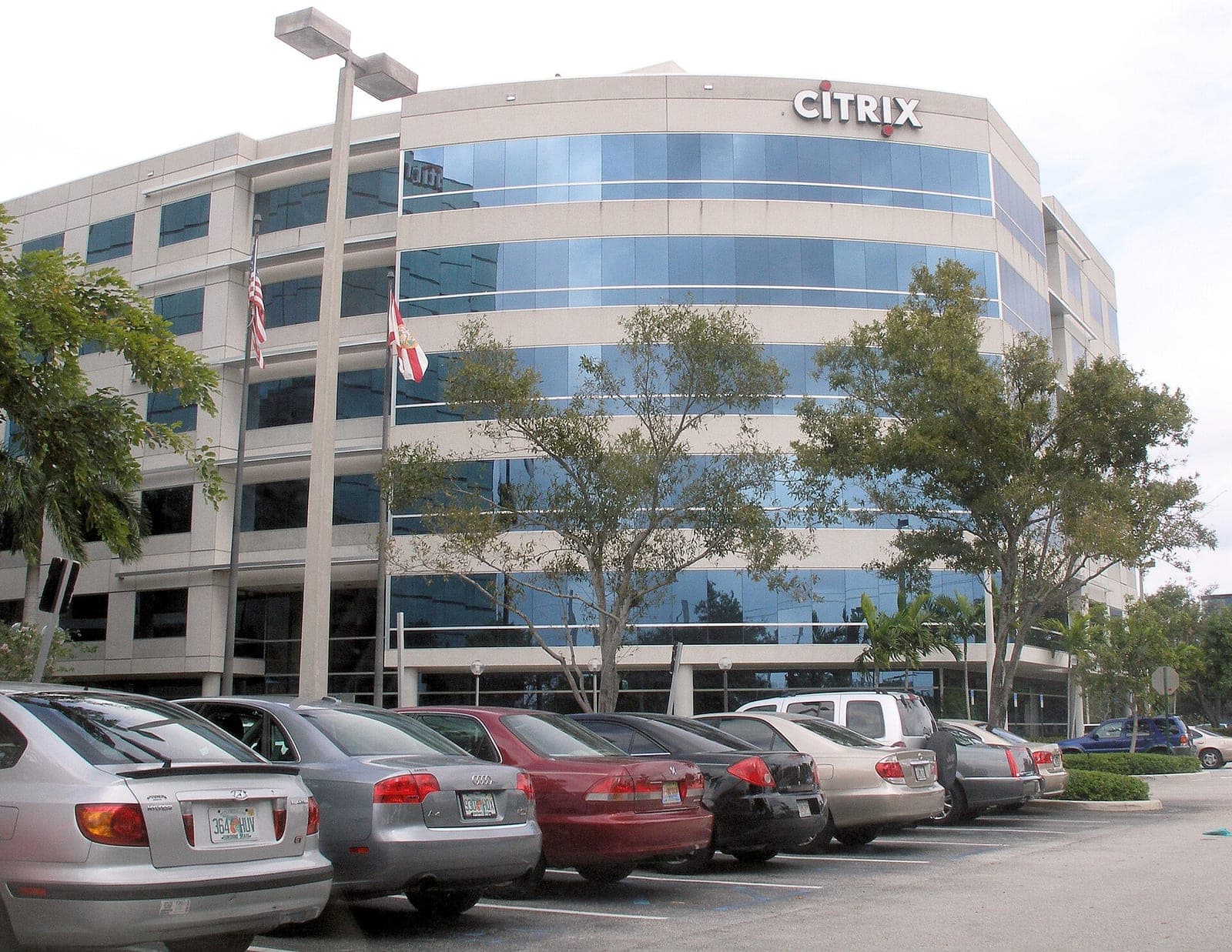 The Citrix Systems headquarters building in Fort Lauderdale, Florida, with a curved glass facade, the Citrix logo near the roof and cars parked in front