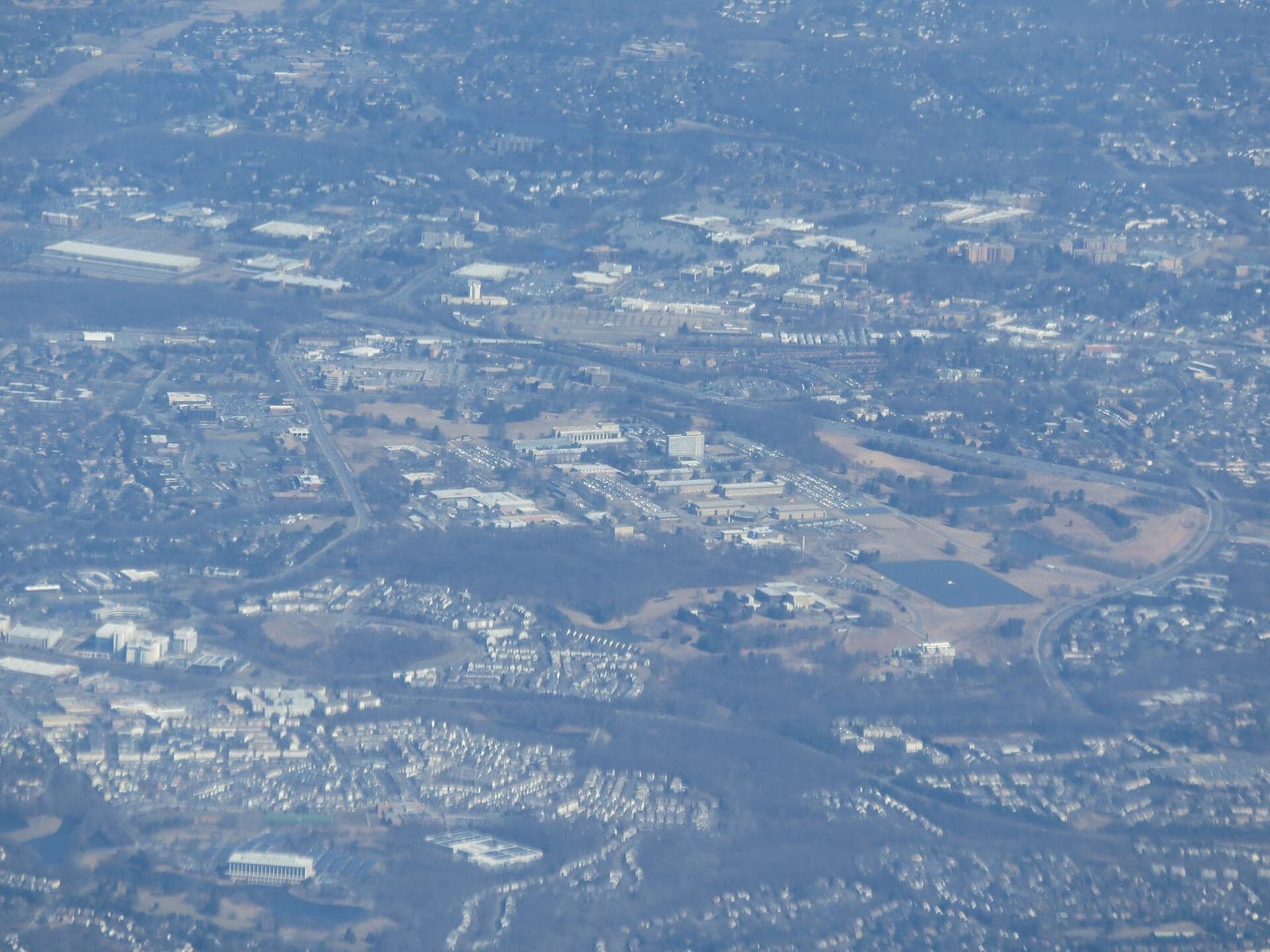 Aerial view of the NIST campus in Gaithersburg, Maryland, with low office buildings and a tall tower among surrounding neighborhoods