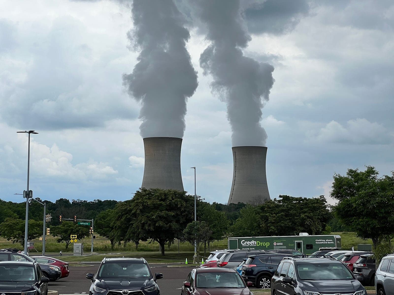 Steam rising from the two cooling towers of the Limerick Generating Station nuclear plant in Pennsylvania, seen across a parking lot