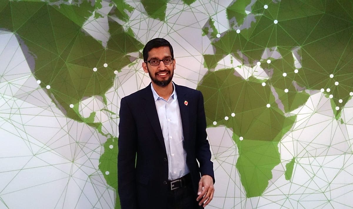 Google CEO Sundar Pichai standing in front of a world map graphic