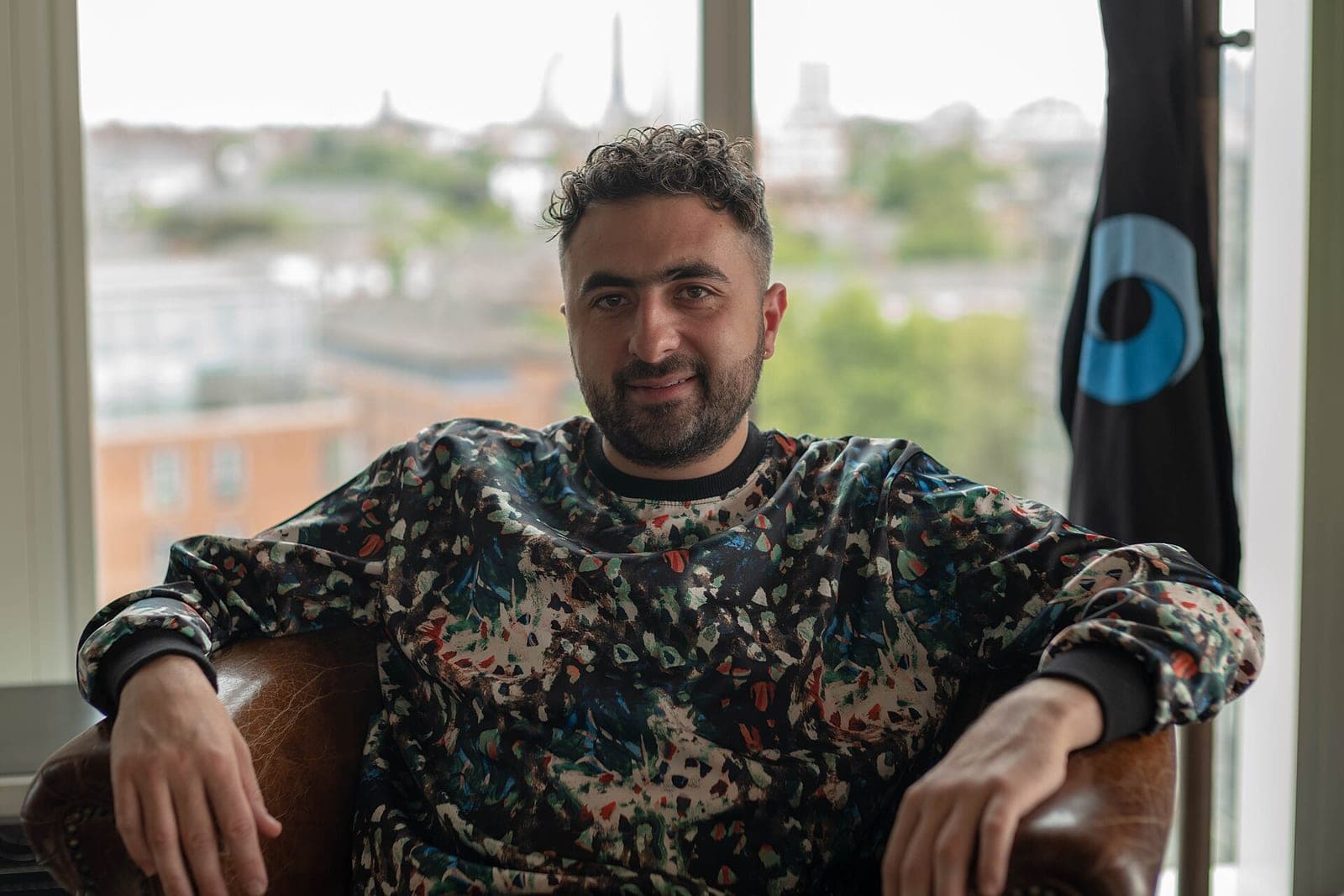 Mustafa Suleyman, who now leads Microsoft AI, sitting in a leather chair by a window in an earlier portrait