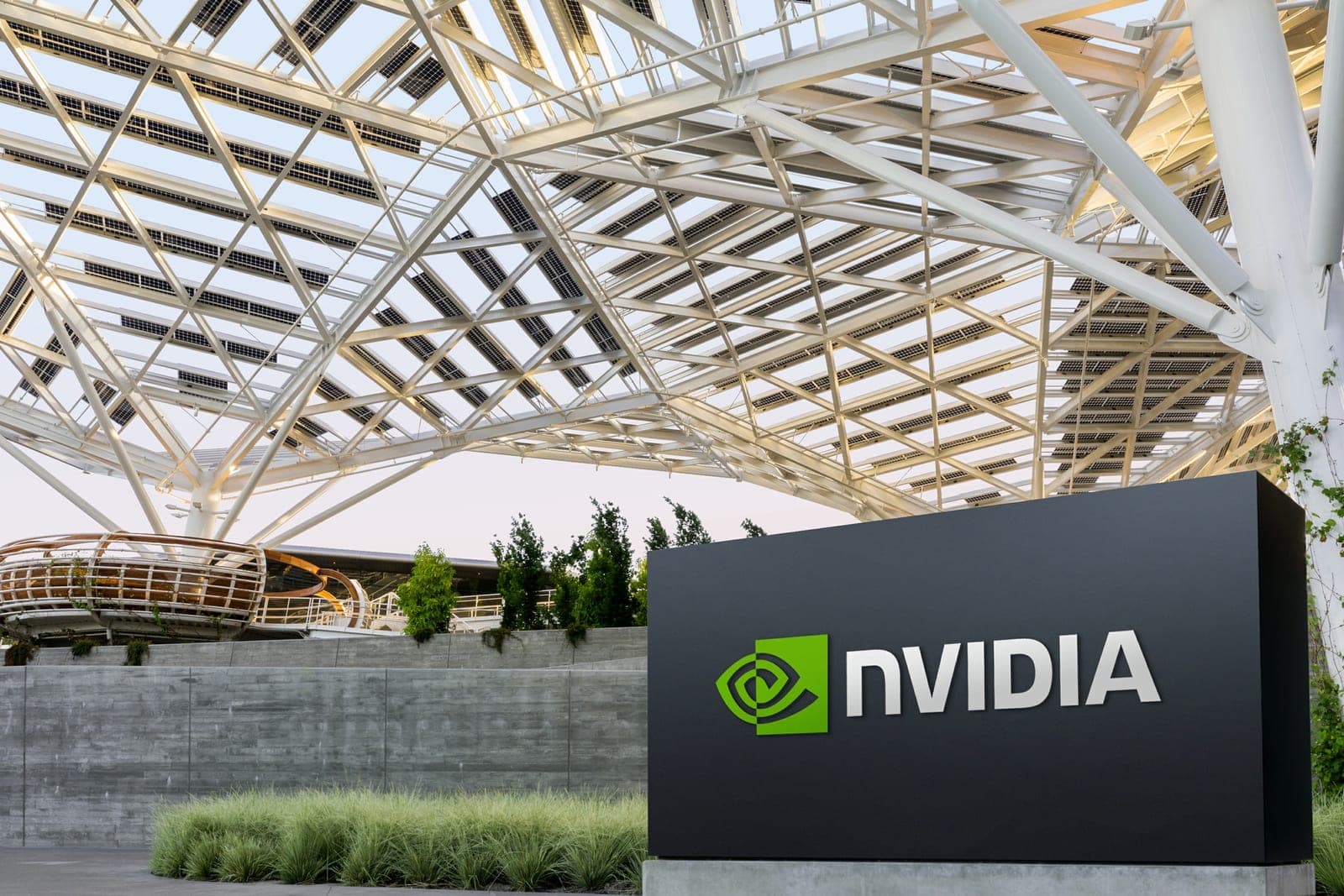 The Nvidia sign and logo outside the company's Santa Clara headquarters, with the distinctive triangular solar-panel canopy visible overhead.