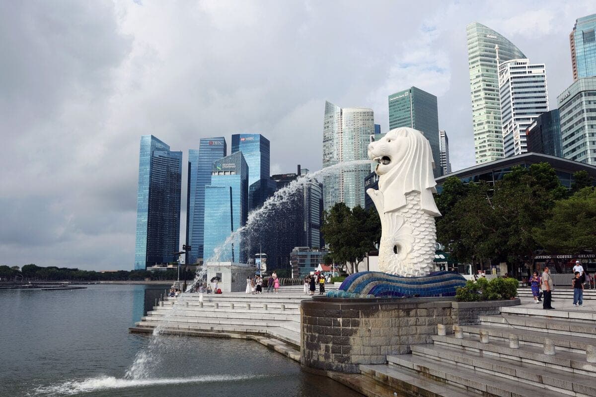 The Merlion statue spouting water in front of Singapore's financial district skyline